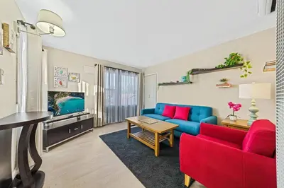a living room with a blue couch and red chairs at Comfy 2 BR House near LAX, SOFI and Intuit Dome! in Inglewood