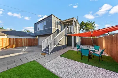 a backyard with a table and chairs and a house at Comfy 2 BR House near LAX, SOFI and Intuit Dome! in Inglewood