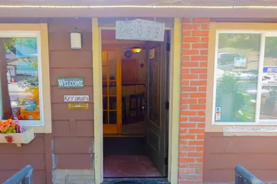 a door to a building with a sign on it at Sleepy Hollow Cabins and Hotel in Crestline