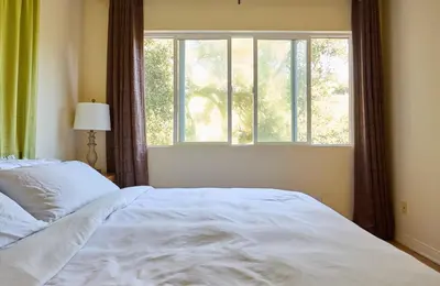 a bedroom with a white bed and a window at Malibu Home in Enchanting Hills 5 min from the beach in Malibu
