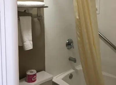 a bathroom with a shower with a toilet and a sink at Corona inn in Corona