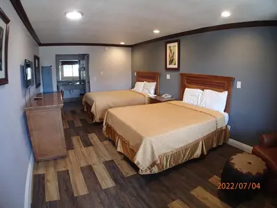 a hotel room with two beds and a television at Corona inn in Corona