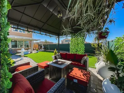 an outdoor patio with red couches and plants at California 3-Bedroom Desert Escape With Garden in Victorville