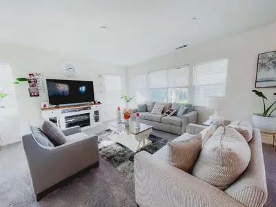 a living room with two couches and a flat screen tv at California 3-Bedroom Desert Escape With Garden in Victorville