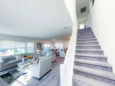 a staircase in a living room with a couch and a table at California 3-Bedroom Desert Escape With Garden in Victorville