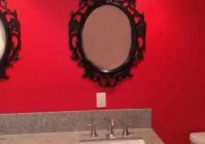 a bathroom with a sink and a mirror on a red wall at MagicwayVillas Cars Theme Pool House - Pool&Spa in Anaheim