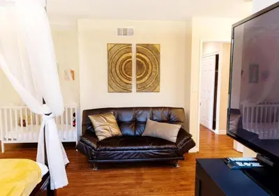 a living room with a leather couch and a television at MagicwayVillas LionQueen - Pool and Spa in Anaheim