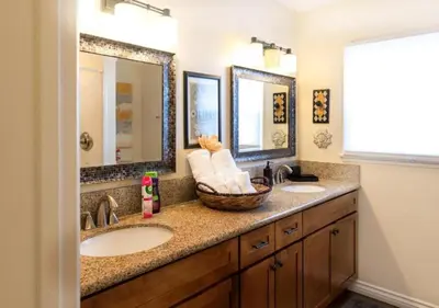 a bathroom with two sinks and two mirrors at MagicwayVillas LionQueen - Pool and Spa in Anaheim