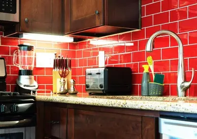 a red tiled kitchen with a counter and a sink at MagicwayVillas LionQueen - Pool and Spa in Anaheim