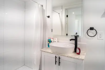 a white bathroom with a sink and a shower at Cozy LA Retreat Near USC Steps to Koreatown & Downtown in Los Angeles