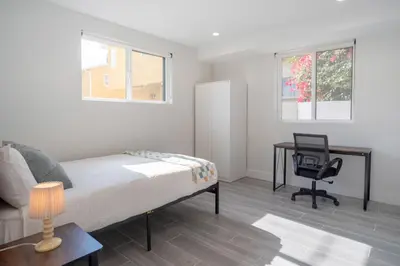 a bedroom with a bed and a desk and a chair at Cozy LA Retreat Near USC Steps to Koreatown & Downtown in Los Angeles