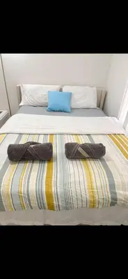 a bed with two slippers on top of it at New renovated room with shared bathroom in Hacienda Heights
