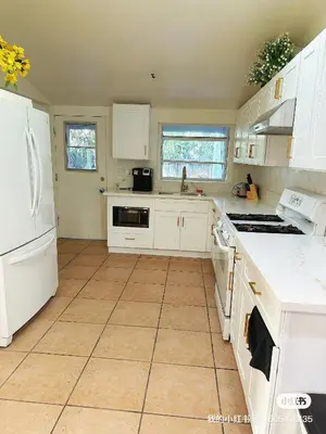a kitchen with white cabinets and a tile floor at New renovated room with shared bathroom in Hacienda Heights