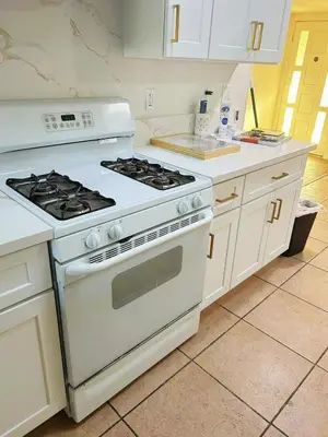 a kitchen with a white stove and white cabinets at New renovated room with shared bathroom in Hacienda Heights