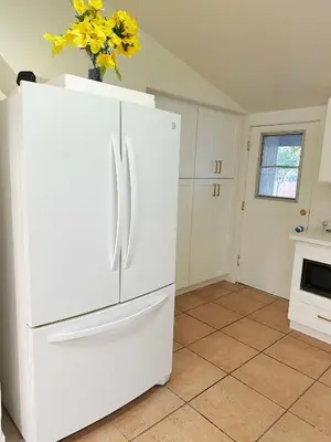 a white refrigerator in a kitchen with a vase of flowers at New renovated room with shared bathroom in Hacienda Heights