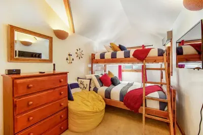 a bedroom with two bunk beds and a dresser at Calm Cozy 3BR cabin wAC, WiFi, Parking, BBQ in Cedar Glen