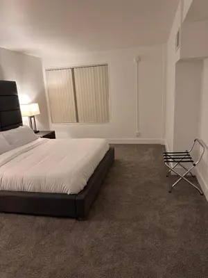 a bedroom with a bed and a chair and a window at Warm and Welcoming in Los Angeles