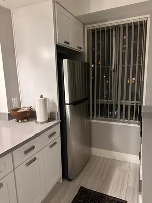 a kitchen with a stainless steel refrigerator next to a window at Warm and Welcoming in Los Angeles