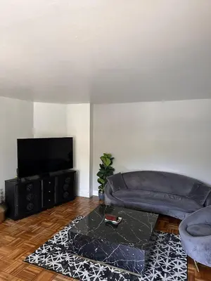 a living room with a couch and a flat screen tv at Warm and Welcoming in Los Angeles