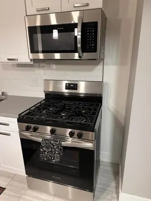 a kitchen with a stove and a microwave at Warm and Welcoming in Los Angeles