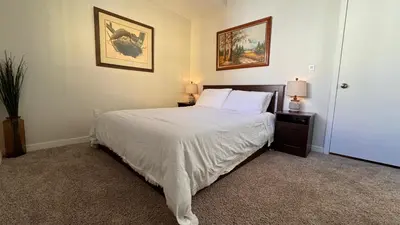 a bedroom with a bed with white sheets and two lamps at Private Room and Bathroom in Los Angeles