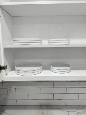 a white shelf with plates on top of it at Stylish & Cozy Retreat in the Heart of LA in Los Angeles