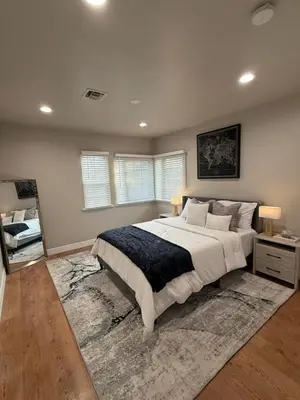 a large bedroom with a large bed and a mirror at Stylish & Cozy Retreat in the Heart of LA in Los Angeles