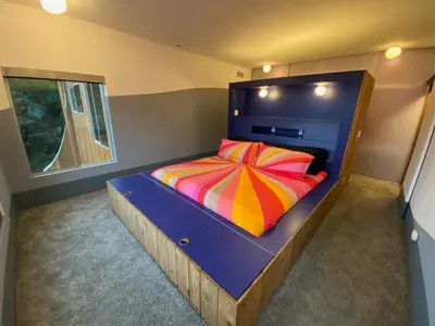 a bedroom with a bed with a colorful striped pillow at The Bernardi House in Los Angeles