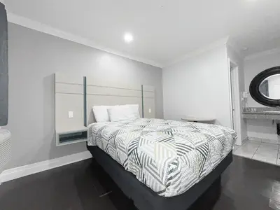 a bedroom with a bed with a striped comforter at Uptown Inn in Long Beach