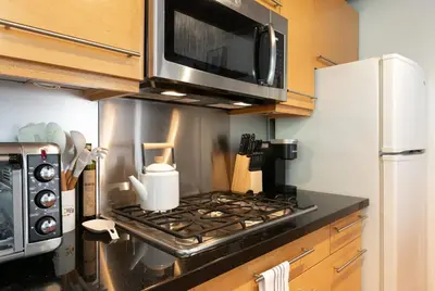 a kitchen with a stove with a microwave above it at Private Venice Beach Loft - Steps to the Beach & Canals in Los Angeles