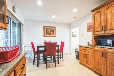 a kitchen with a table and red chairs in a room at Peaceful Oasis in Anaheim