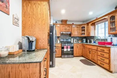 a kitchen with wooden cabinets and a black refrigerator at Peaceful Oasis in Anaheim