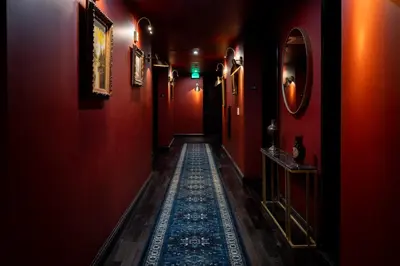 a long hallway with red walls and a rug on the floor at Whisky Hotel in Los Angeles