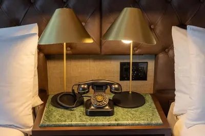 a telephone and two lamps on a table between two beds at Whisky Hotel in Los Angeles