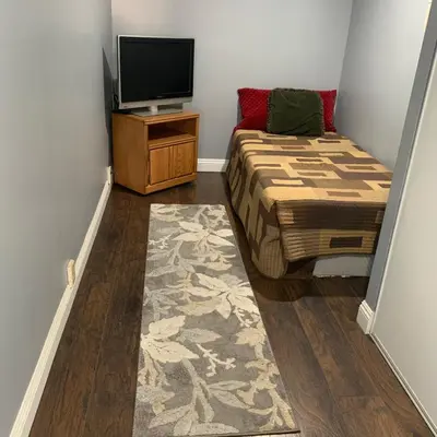 a small bedroom with a bed and a television at Cozy Room in Bakersfield