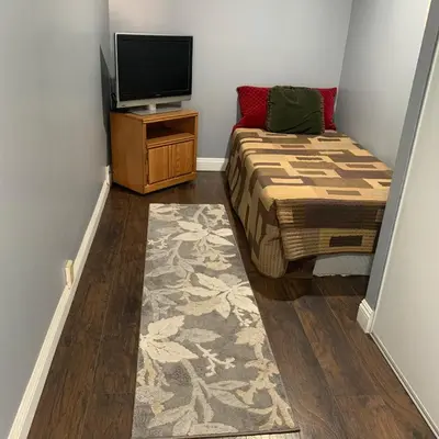 a small bedroom with a bed and a television at Cozy Room in Bakersfield