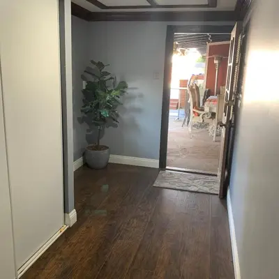 a hallway with a door and a potted plant at Cozy Room in Bakersfield