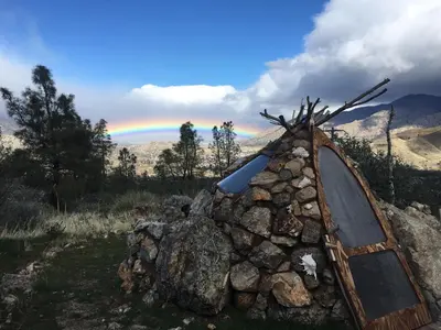 a pile of rocks with a rainbow in the background at Big Glamping Teepee in Bodfish