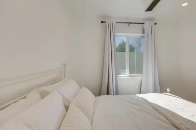 a white bed in a room with a window at 35 Mi to LA Modern Apartment in Chino! in Chino