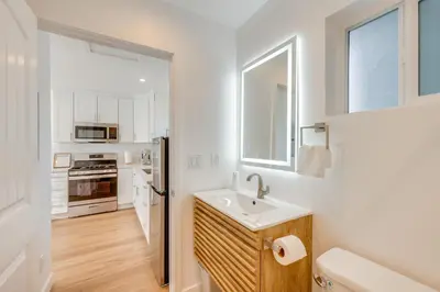 a white kitchen with a sink and a refrigerator at 35 Mi to LA Modern Apartment in Chino! in Chino