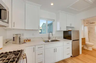 a kitchen with white cabinets and a stainless steel refrigerator at 35 Mi to LA Modern Apartment in Chino! in Chino