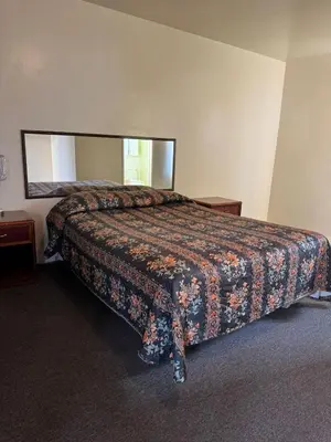 a bedroom with a bed with a large mirror at El Rancho Motel, Pasadena in Pasadena