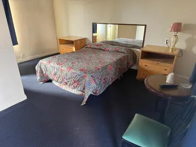 a hotel room with two beds and a mirror at El Rancho Motel, Pasadena in Pasadena