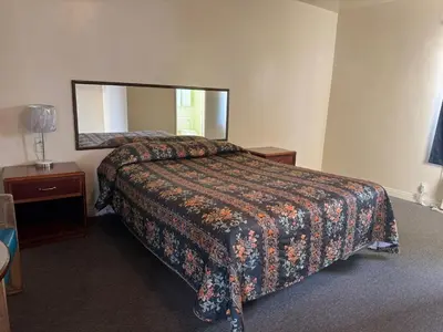 a hotel room with a bed and a mirror at El Rancho Motel, Pasadena in Pasadena