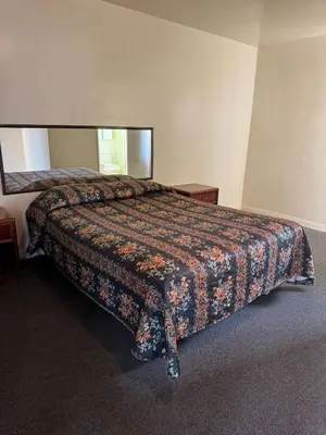 a bed in a hotel room with a comforter at El Rancho Motel, Pasadena in Pasadena