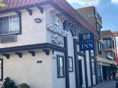 a building with a sign on the side of it at Sunrise Inn in Gardena