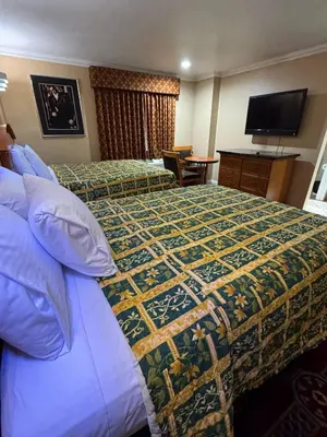 a hotel room with a bed and a television at Sunrise Inn in Gardena