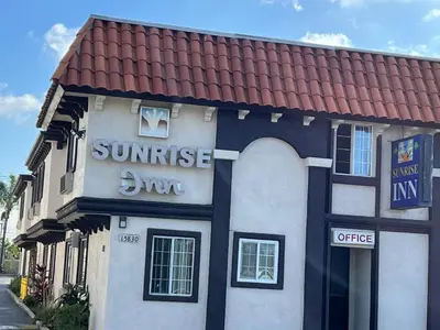 a building with a sunset sun sign on it at Sunrise Inn in Gardena