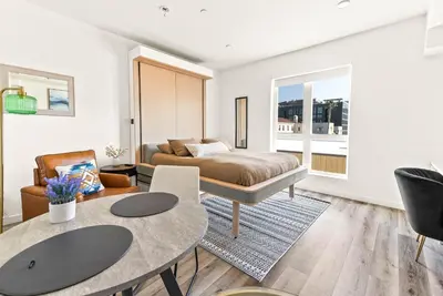 a living room with a bed and a table at Modern Hollywood Studio, Pool Parking Gym in Los Angeles