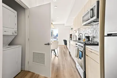 a kitchen with white cabinets and a stove top oven at Modern Hollywood Studio, Pool Parking Gym in Los Angeles